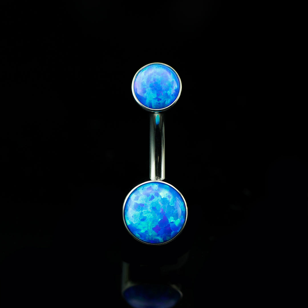 Navel curve with two dark blue colored opals at the top and bottom on a black background.