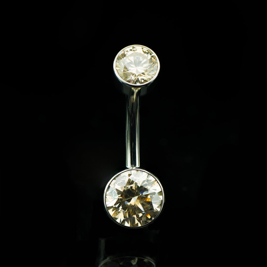 Navel curve with round champagne colored gems at the top and bottom on a black background.