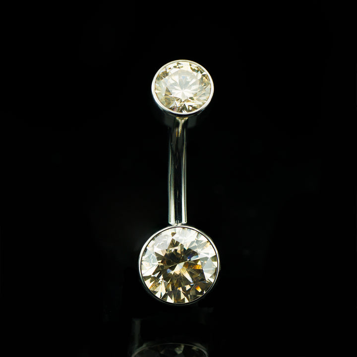 Navel curve with round champagne colored gems at the top and bottom on a black background.