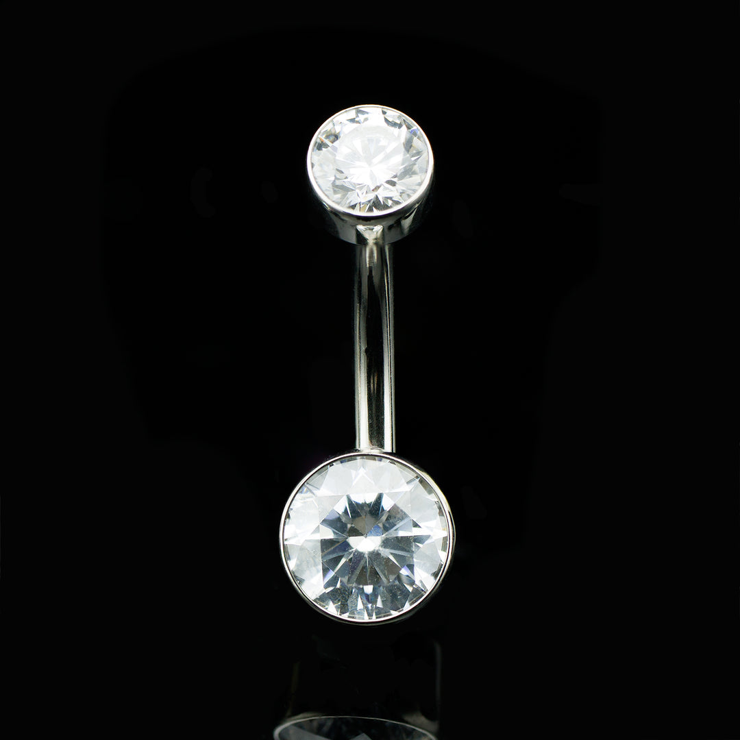 Belly button ring with two CZ gemstones on a black background
