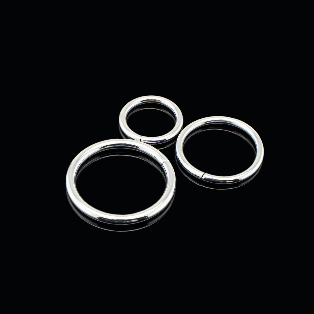 Three silver color rings of varying sizes on a black background.