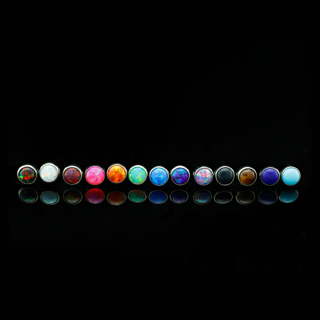 Row of cabochons (a round and smooth cut for opals and some stones) in varying colors.