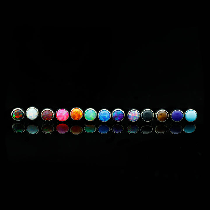 Row of cabochons (a round and smooth cut for opals and some stones) in varying colors.