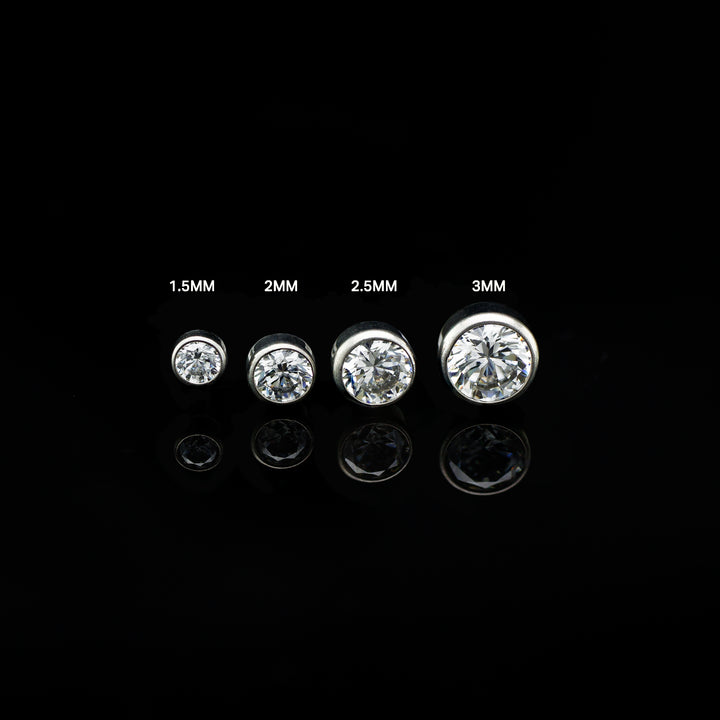 Row of four bezel set white cubic zirconia in varying sizes on a black background. The pieces are size labeled from left to right in ascending sizes.