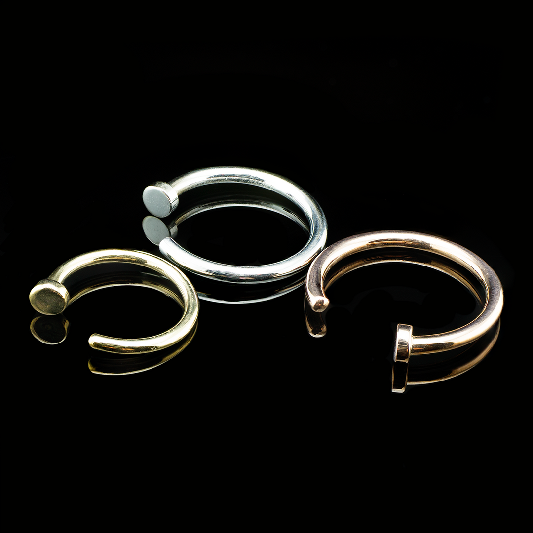 3 nostril nails in varying sizes and gold tones set on a black background. 
Nose piercing jewelry from BVLA