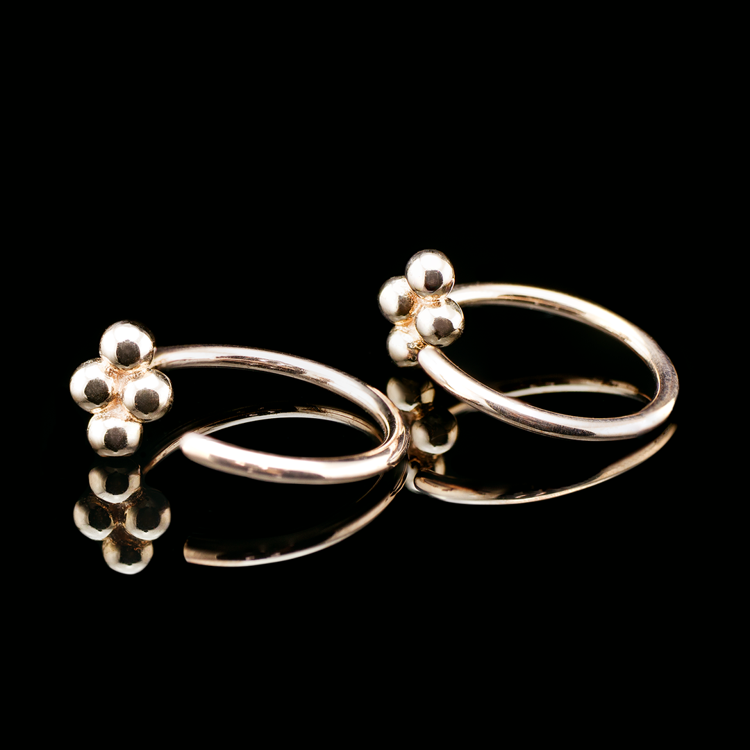 Two rose gold nostrils nails with a quad bead design on both set on a black background. The quad bead design consists of 4 beaded shapes sawdered in a diamond shape.
Perfect for earlobes and nostrils