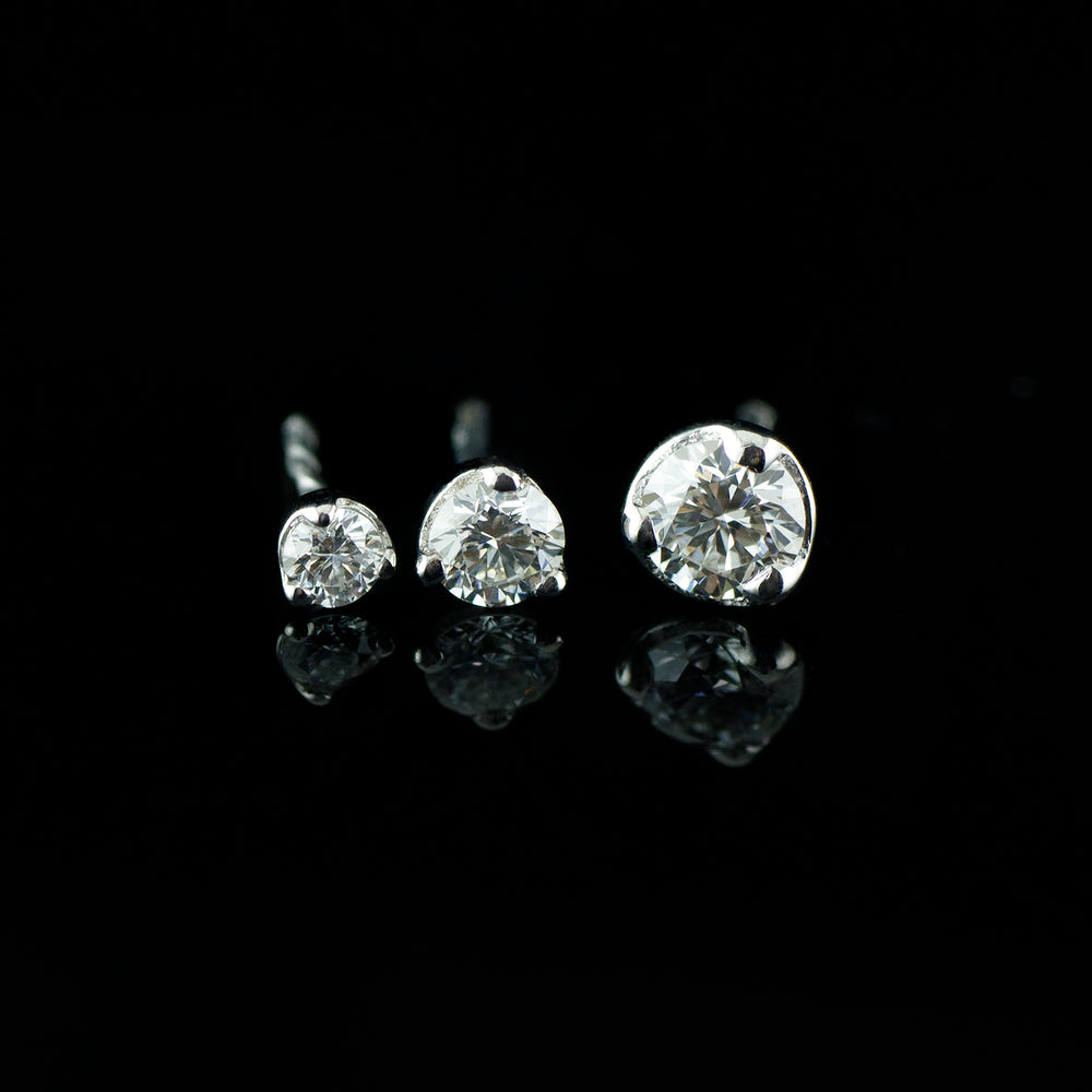 Three diamonds set in 3 white gold prongs on a black background.