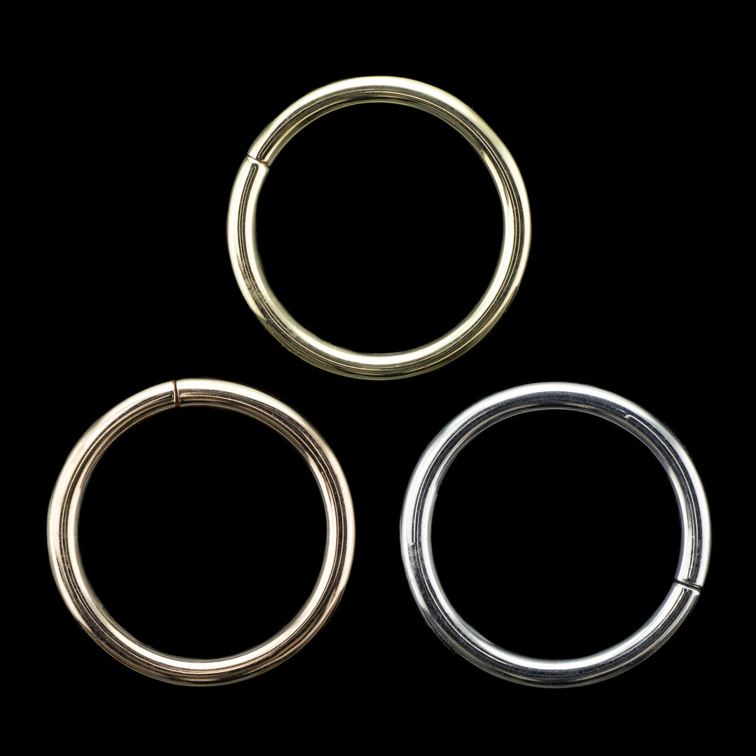 Solid gold seamless hoops on a black background. 3 simple high polish rings for belly, navel, nostril, daith, cartilage, helix, rook, tragus, earlobe piercings. 