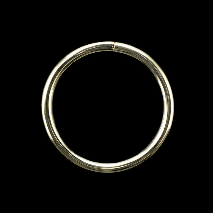 Solid yellow gold seamless hoop on a black background. A high polish ring for belly, navel, nostril, daith, cartilage, helix, rook, tragus, earlobe piercings. 