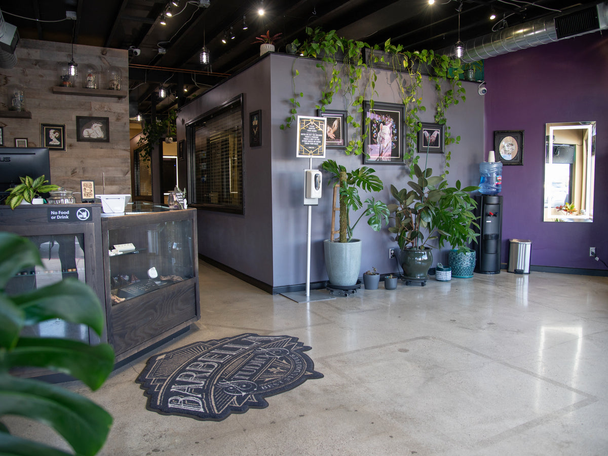 Photo of Barbella's lobby, full of plants, framed artwork, jewelry cases, and a water dispenser.