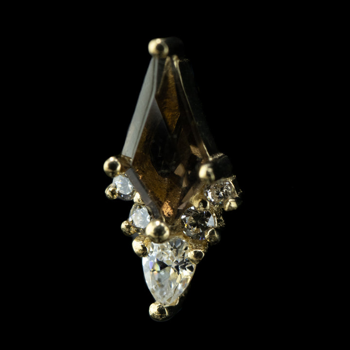 side view of a piece of body jewelry that is a cluster of six gems set in white gold prongs. At the center is a large kite cut Smoky quartz with 5 cubic zirconia lining the bottom two sides of the cut kite garnet. the center and lowest cz is a smaller pear cut white cz facing downwards. there are two smaller round cut white czs on either side of the pear cut cz. 