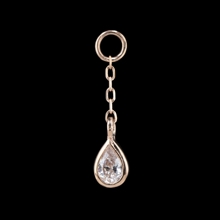 a rose gold body chain charm on a black background. The piece is a length of cable chain attached to a jump ring with a bezel set pear Cubic Zirconia on the end.