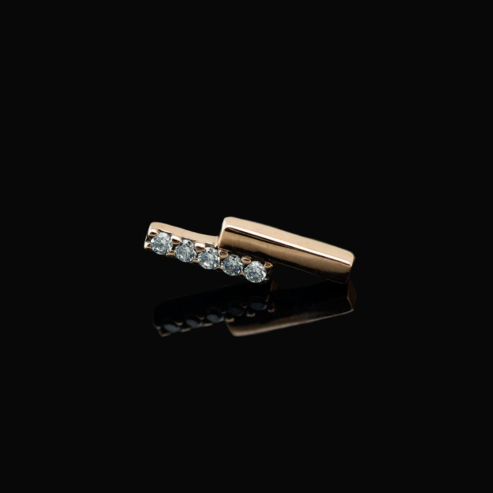 Rose gold piece of body jewelry consisting of two offset bars, one set with 5 white CZs. 