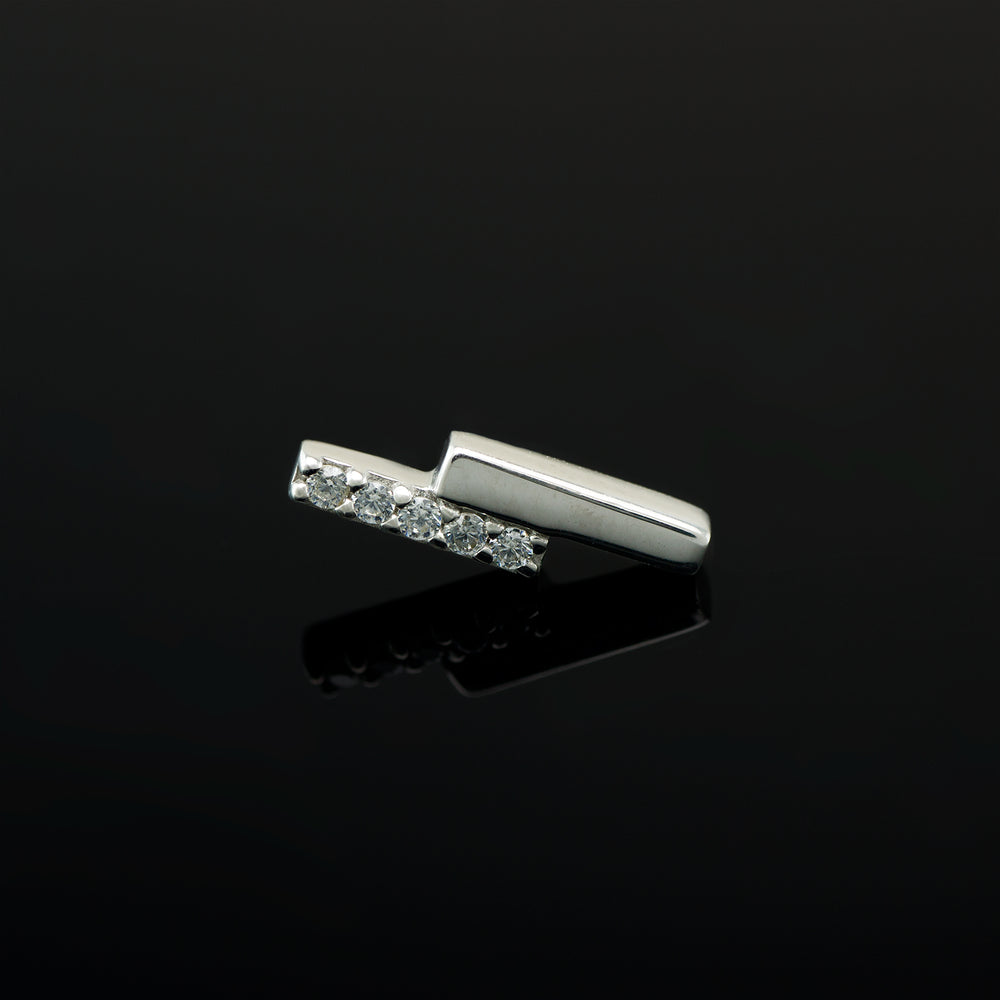White gold piece of body jewelry consisting of two offset bars, one set with 5 white CZs