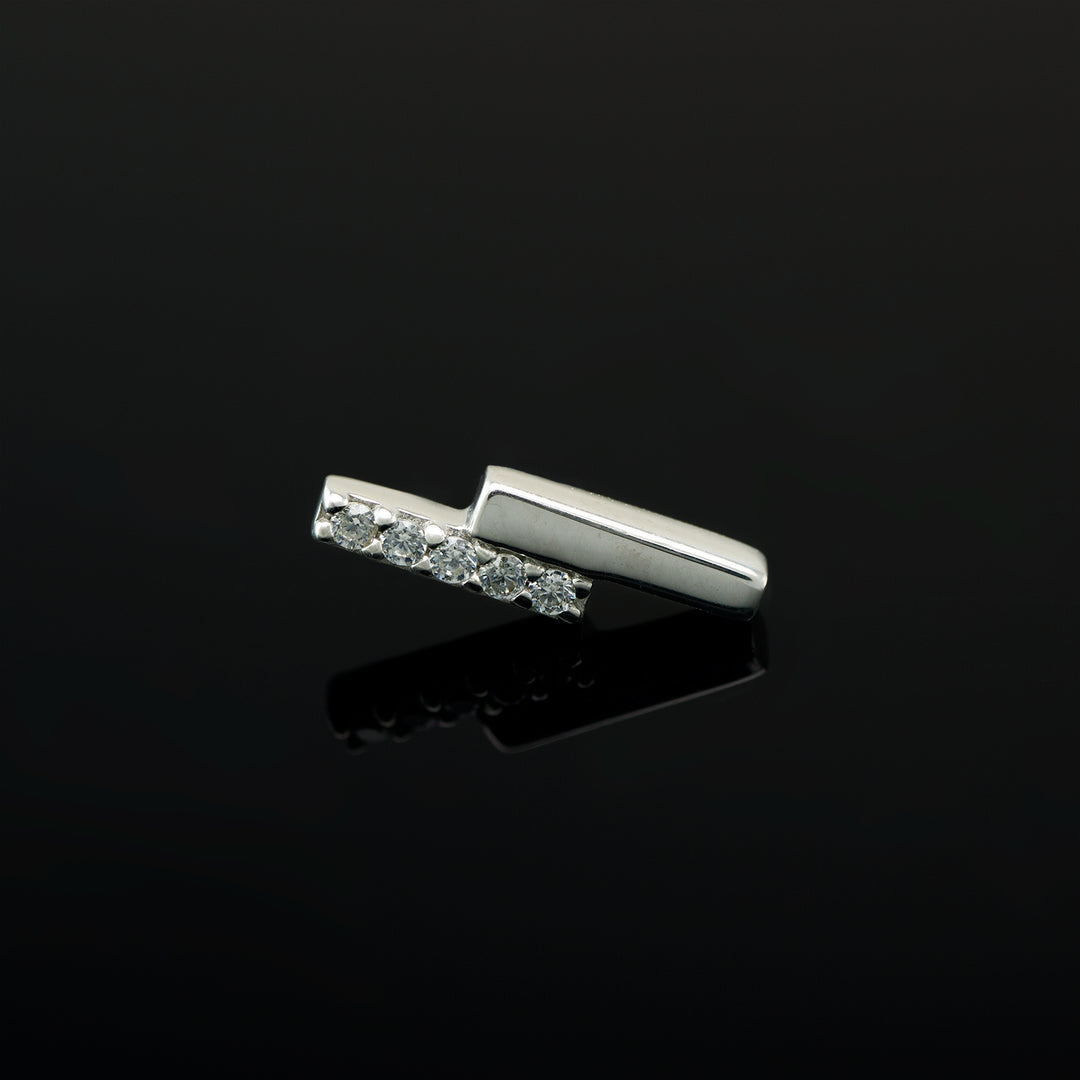 White gold piece of body jewelry consisting of two offset bars, one set with 5 white CZs