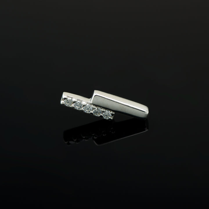 White gold piece of body jewelry consisting of two offset bars, one set with 5 white CZs