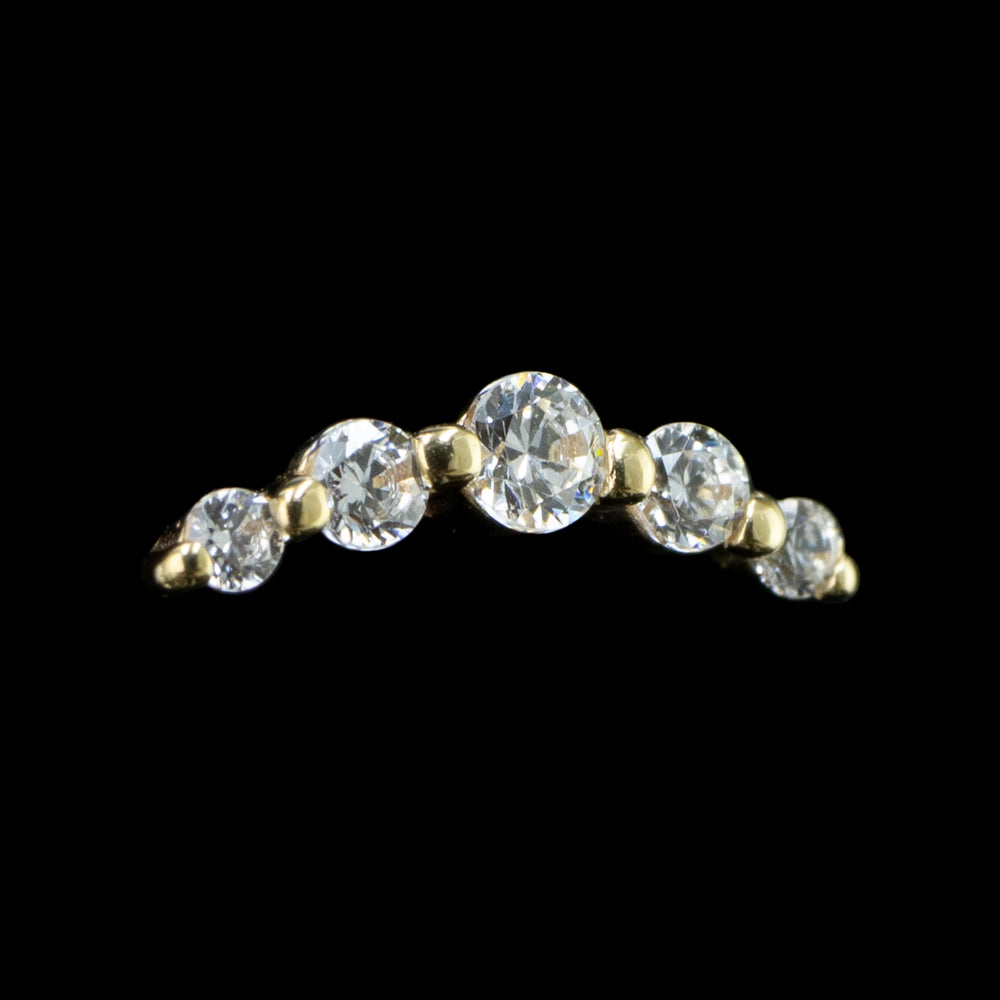 A yellow gold threadless end featuring five sparkling crystals arranged in a curved line design, intended for use with ear piercings.