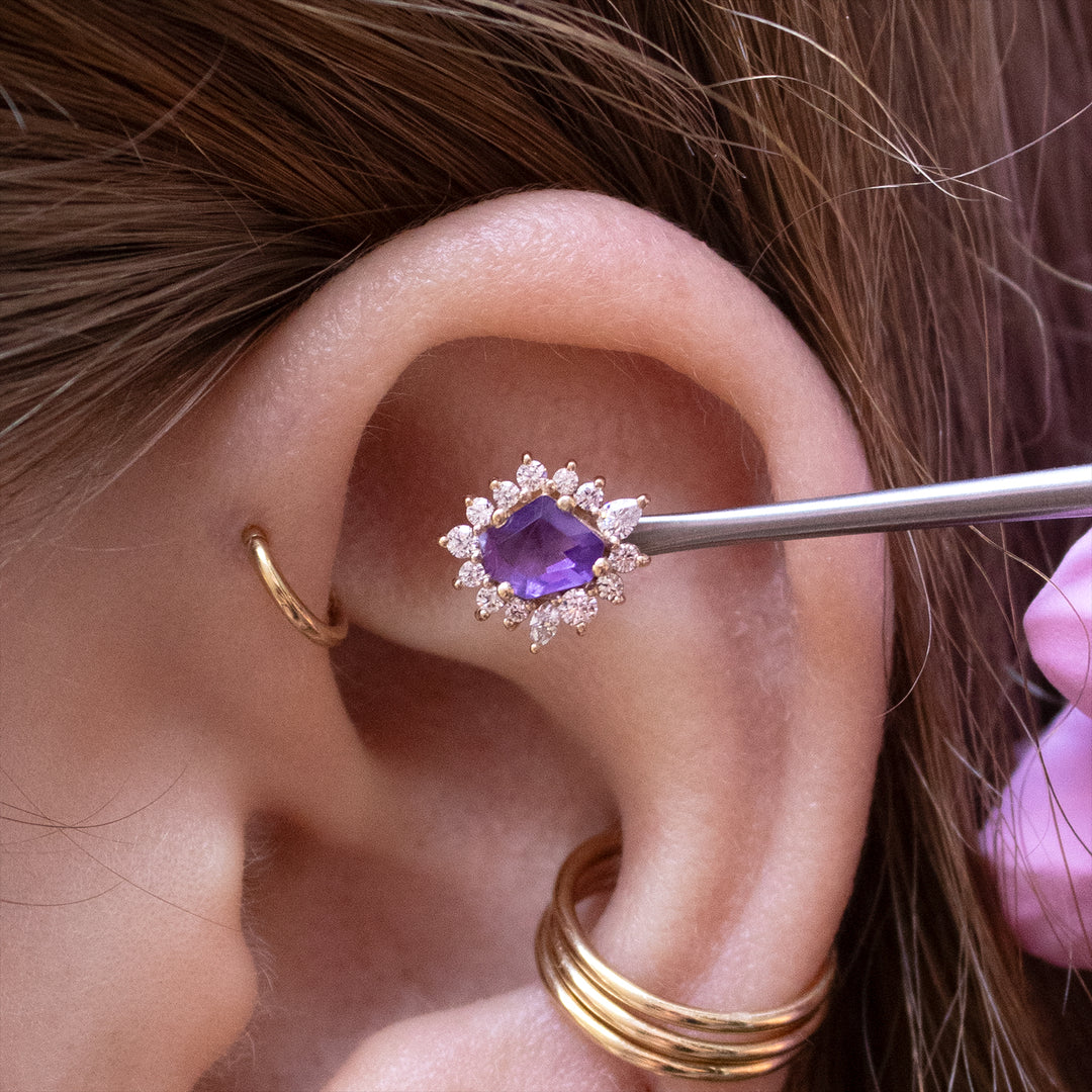 Close-up of the upper half of an ear with the amethyst eye candy shown in a flat placement.