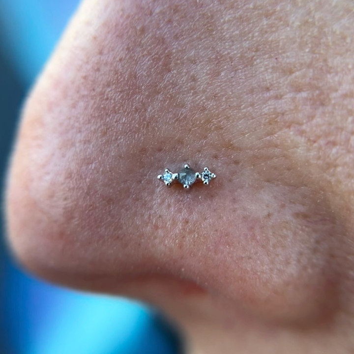 A close up of a nose piercing wearing a Threadless Ghost Flower end from Buddha Jewelry.