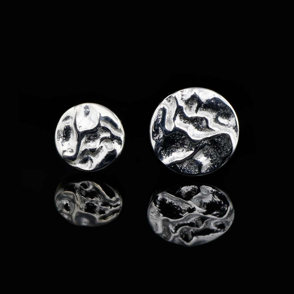White gold hammered disks in two different sizes on a black background.