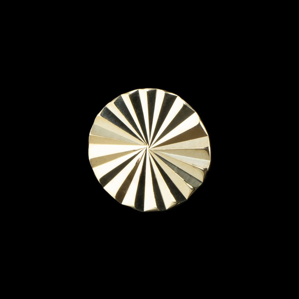 A yellow gold disk with laser cut texture 