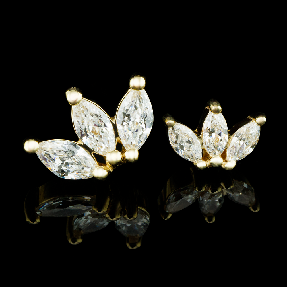 Two yellow gold Moets with white cz stones set on a black background.