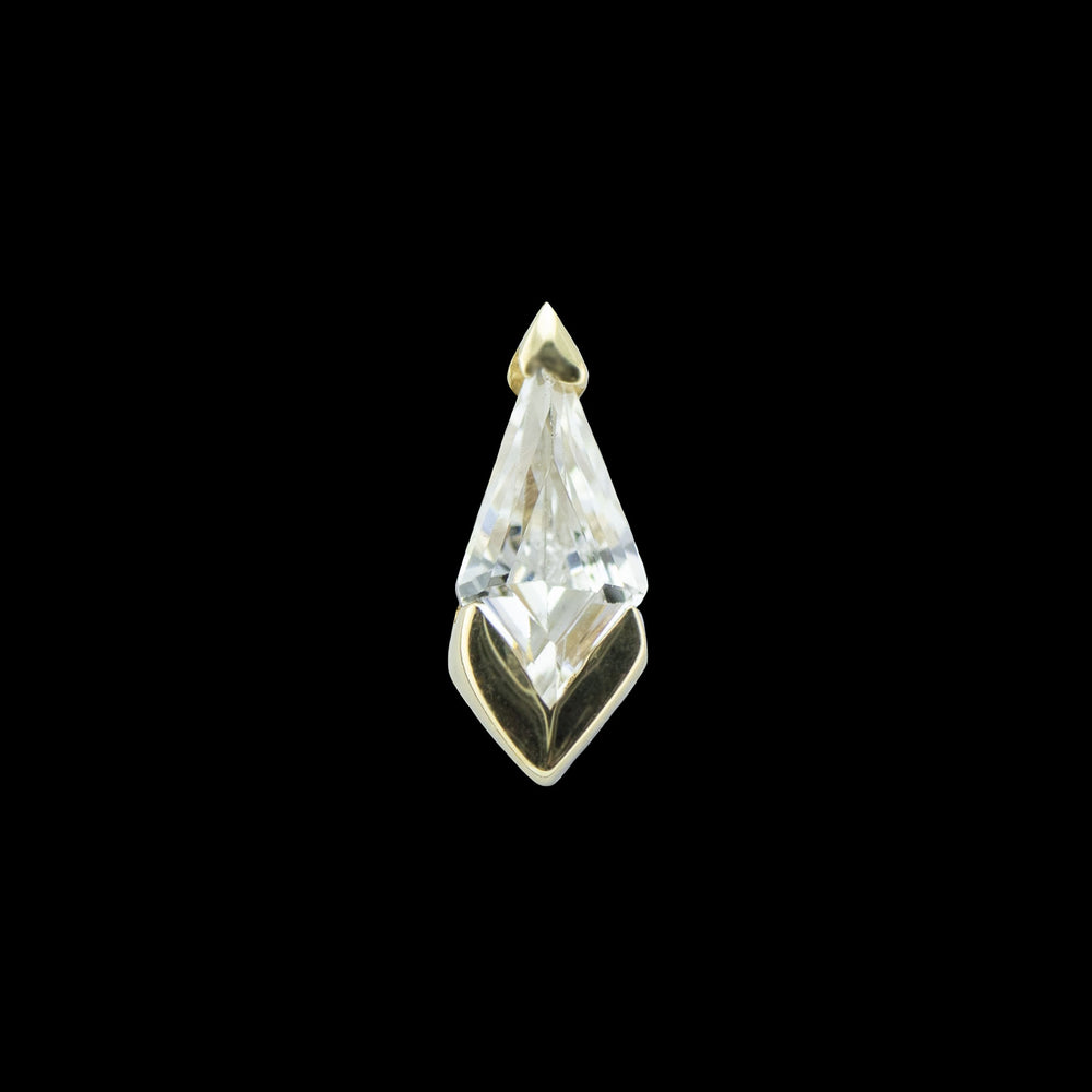 A yellow gold piece of body jewelry on a solid black background. This piece consists of a kite cut Swarovski cubic zirconia set into 2 v shaped prongs at the top and bottom of the cz. 