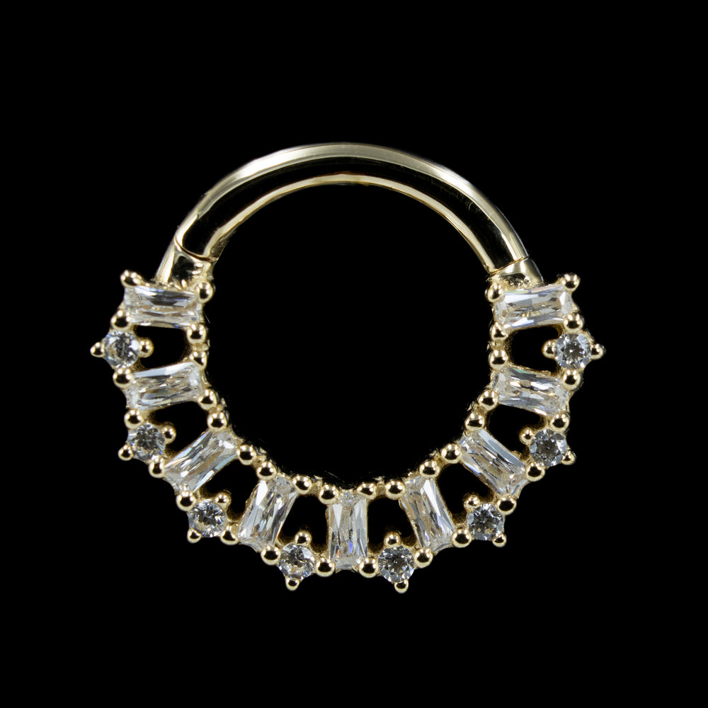 A yellow gold Obsessed Clicker on a black background.