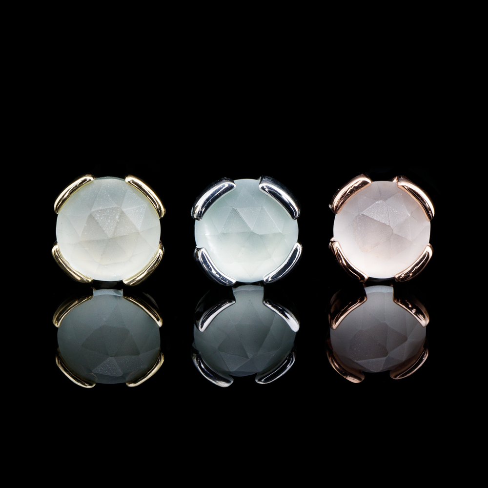 Three round body jewelry pieces with sandblasted aquamarine on a black background