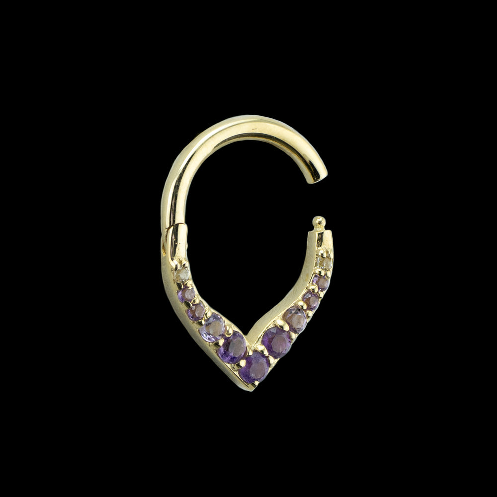 A yellow gold piece of body jewelry on a black background. This image shows a side view of this design. The hinge is opened showing the closure mechanism.
 It is a V shaped hinge body ring with 11 round cut amethyst set into the v. At the bottom point is a larger sized amethyst with smaller descending sizes going up the hoop. The center largest 3 gems are the deepest in color and they fade to a lighter purple as they go up the ring.  