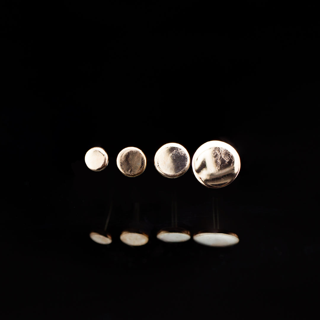 A row of rose gold circles arranged in ascending sizes on a black background.