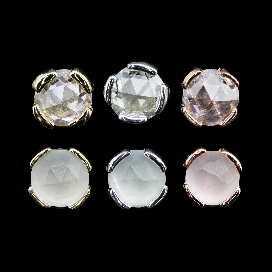 Three Peakaboo threadless ends with rose cut white cz and sandblasted aquamarine from Buddha Jewelry on a black background. The Peakaboo end design is a rose cut stone set in a 4 prong/ bezel hybrid setting.