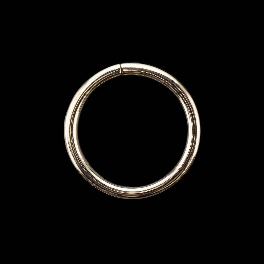 Solid rose gold seamless hoop on a black background. A simple high polish ring for belly, navel, nostril, daith, cartilage, helix, rook, tragus, earlobe piercings. 