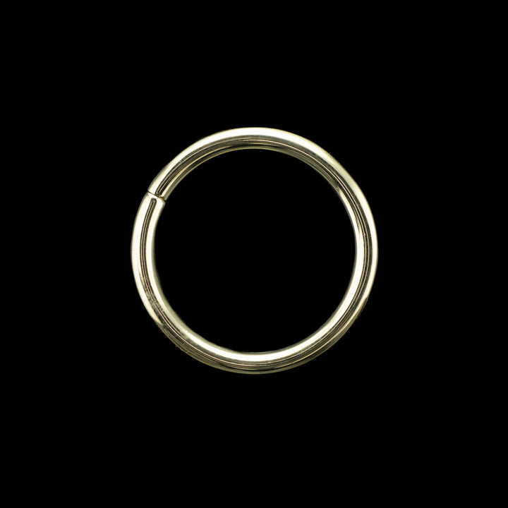 Solid yellow gold seamless hoops on a black background. A simple high polish rings for belly, navel, nostril, daith, artilage, helix, rook, tragus, conch earlobe piercings. 