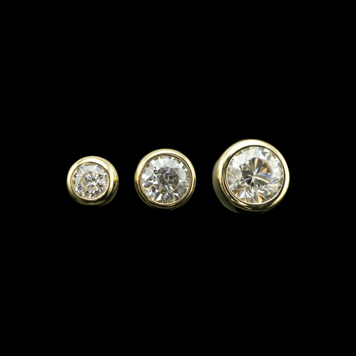 3 varying sizes of cubic zirconia set in a yellow gold bezel. 