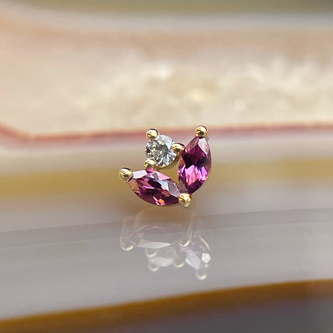 Yellow Gold Bloom end from BVLA photographed on an agate slab. Pink rhodolite garnet and white cz in yellow gold. Perfect for nostril and ear piercings. 