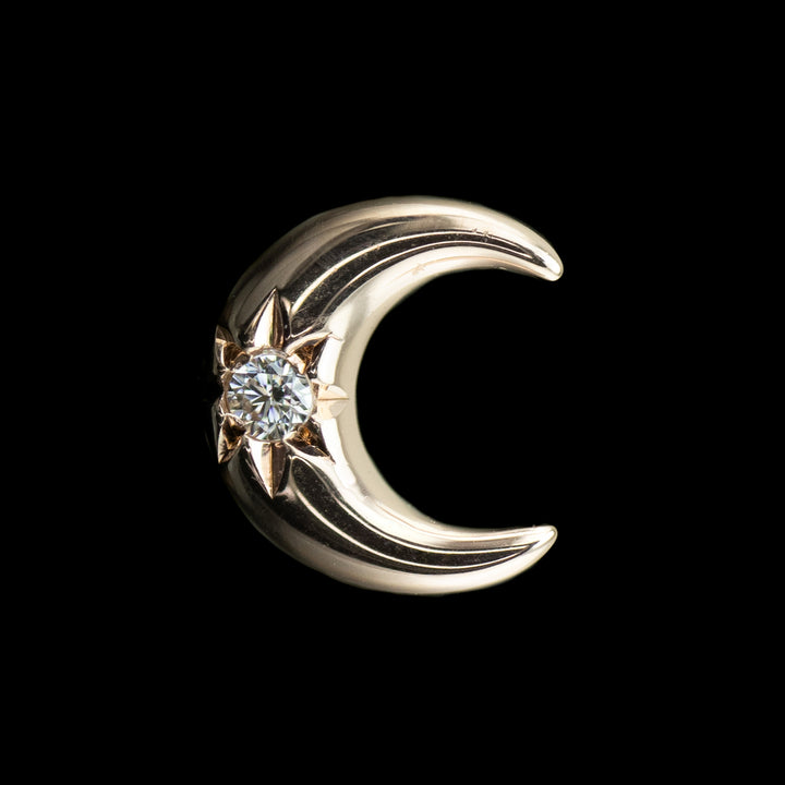 rose gold body jewelry in the shape of a moon with a white cubic zirconia center.