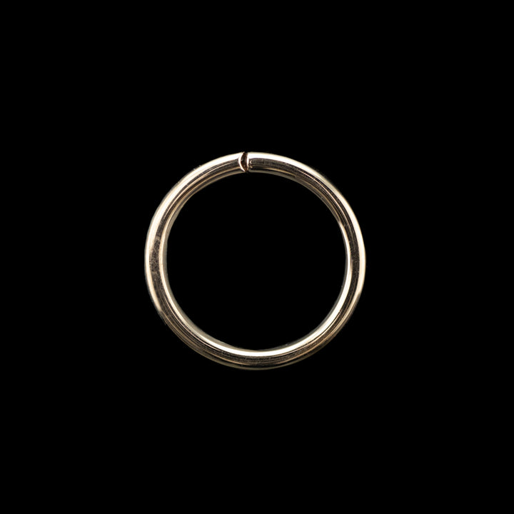 Solid rose gold seamless hoop on a black background. A simple high polish ring for belly, navel, nostril, daith, cartilage, helix, rook, tragus, earlobe piercings. 